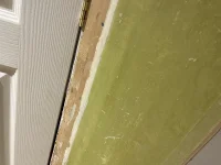 Green and yellow paint under old wallpaper